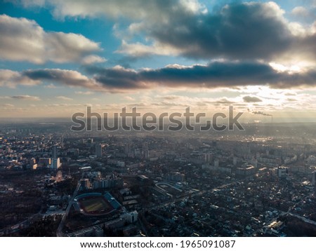 Aerial panoramic view of Kharkiv city center with Park of Maxim Gorky, stadium and residential multistorey buildings with scenic bright cloudy sky in winter