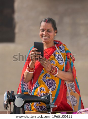 Happy RURAL WOMAN Holding Mobile while reading text message
 Royalty-Free Stock Photo #1965100411