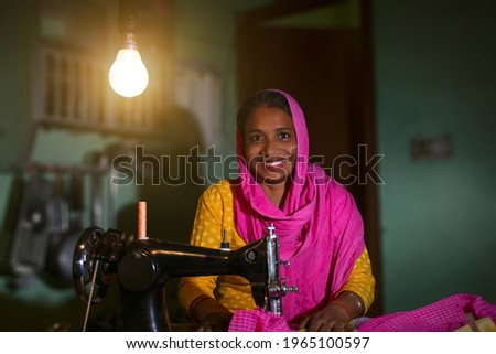 PORTRAIT OF A RURAL WOMAN SEWING CLOTHES
 Royalty-Free Stock Photo #1965100597