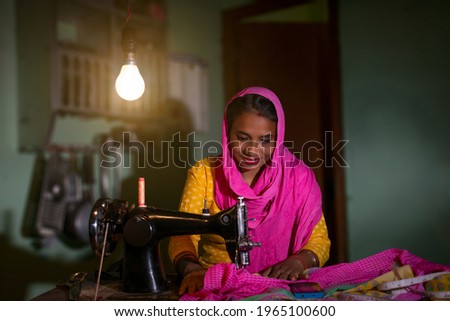 PORTRAIT OF A RURAL WOMAN SEWING CLOTHES
 Royalty-Free Stock Photo #1965100600