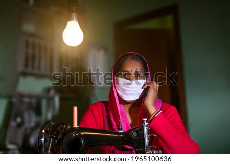 PORTRAIT OF A RURAL WOMAN WEARING MASK and talking on a mobile phone
 Royalty-Free Stock Photo #1965100636