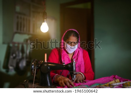 PORTRAIT OF A RURAL WOMAN WEARING MASK AND SEWING CLOTHES
 Royalty-Free Stock Photo #1965100642