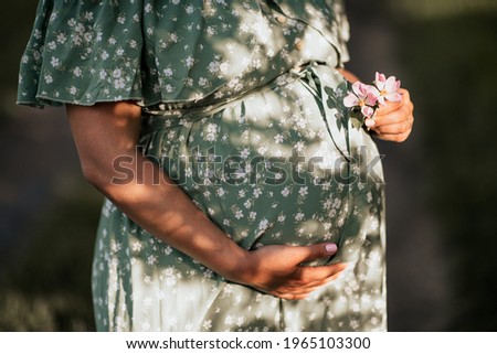 Maternity belly, outdoor image with warm light