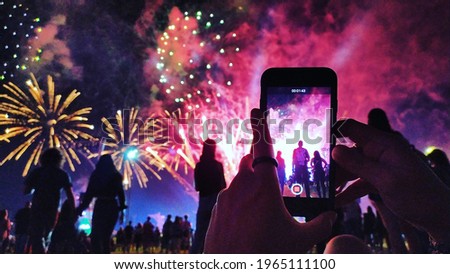 Picture of some people watching fireworks in a concert.