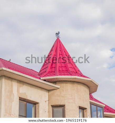 The roof is made of metal. Metal roofing sheets. Modern types of roofing materials. House roof, metal tiles against the blue sky.