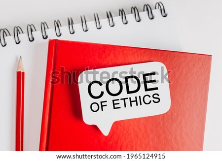 Text Code of Ethics on a white sticker with office stationery background. Flat lay on business, finance and development concept