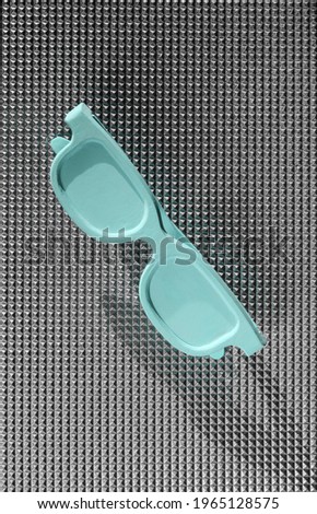 Blue glasses on a silver background. summer vacation concept