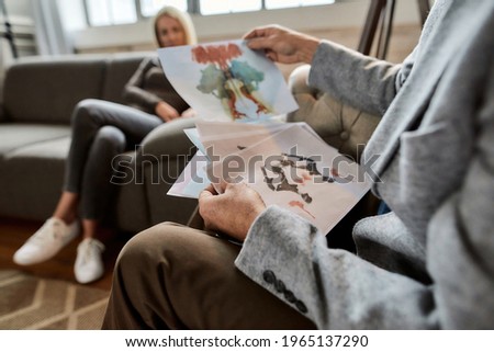 Psychologist using inkblot test in attempt to examine personality characteristics and emotional functioning of young woman during session in office. Psychotherapy concept Royalty-Free Stock Photo #1965137290