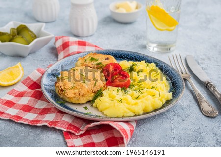 Homemade fish cakes or cutlets with mashed potatoes on a blue plate on a light concrete background. Fish recipes.