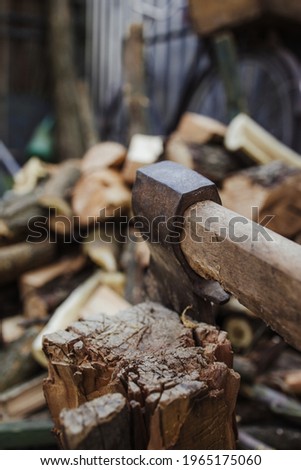 Big ax with chopped woods blurred on background.