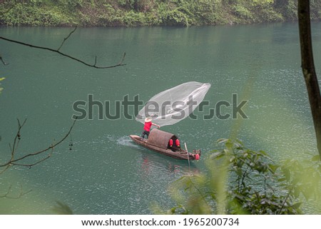 A high angle shot of a fisherman on a fishing boat captured in Hunan, China