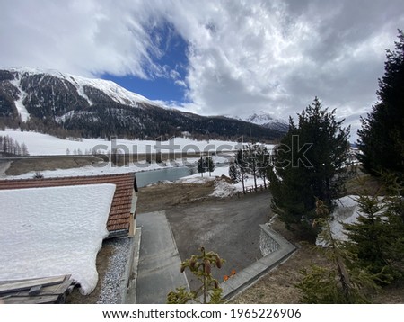 A chilling view of snow-covered houses near a road with a snowy mountain background