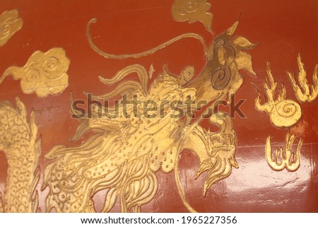 A Chinese golden artwork on a red wall