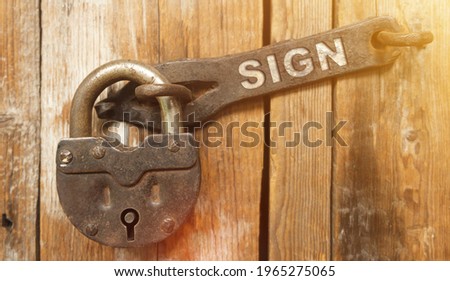 Security concept. There is a lock on the door on the metal part of which it is written - SIGN