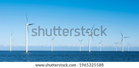 wind turbines in water of ijsselmeer near Urk in dutch part of noordoostpolder under blue sky in the netherlands Royalty-Free Stock Photo #1965325588