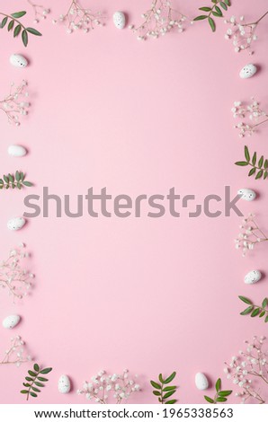 Eggs, gypsophila and green twigs on a pink background. Frame. Easter concept. Copy space background. Flat lay.