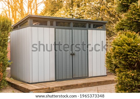 Modern summer house made of plastic. Gray garden shed for garden tools.	gray garden shed made of plastic. Modern tool shed Royalty-Free Stock Photo #1965373348