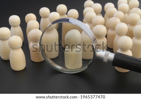 People recognition and identifying concept. Many figures of people as crowd of people and magnifying glass on black background. Royalty-Free Stock Photo #1965377470