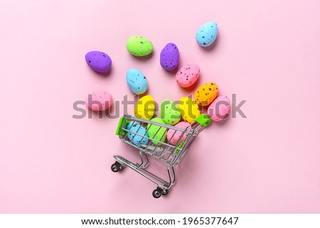 colorful quail eggs scattered from the cart on trendy pink background Funny decoration Happy Christian Easter celebration Handmade concept Springtime