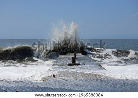Stormy dirty waves crash on a concrete pier