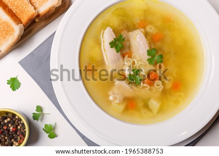 Chicken soup with noodle, vegetable in bowl