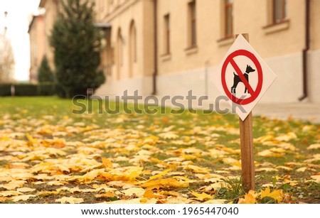 No dogs allowed sign in park on sunny autumn day