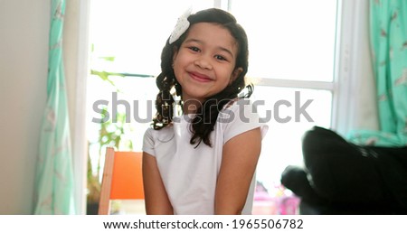 Mixed race little girl child smiling at camera. Portrait hispanic with Asian descent