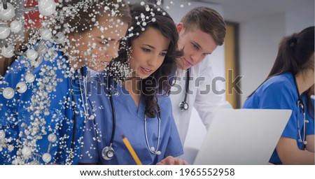 Composition of white molecules over male and female doctors using laptop. global technology, medicine, research and digital interface concept digitally generated image.