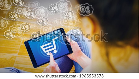 Multiple bubbles with settings icons over woman using tablet with shopping cart graphic on screen. global technology, data processing and digital interface concept digitally generated image.