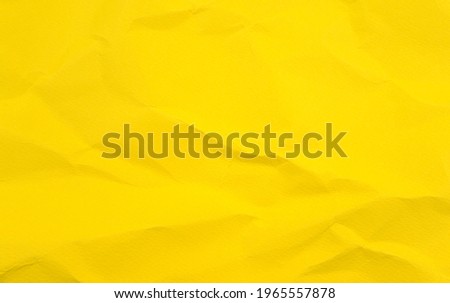 Vivid colorful wrinkled crumpled calendula, marigold yellow blank paper texture abstract background.