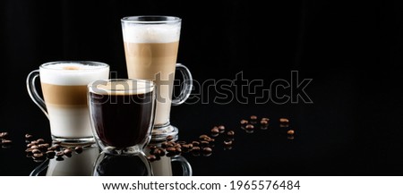 horizontal banner with different types of coffee in glasses on a black mirror background, cappuccino, americano, latte macchiato, coffee beans Royalty-Free Stock Photo #1965576484