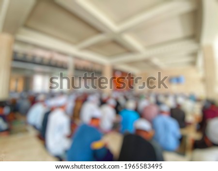 An abstract background that is not the focus of the people worshiping in the mosque