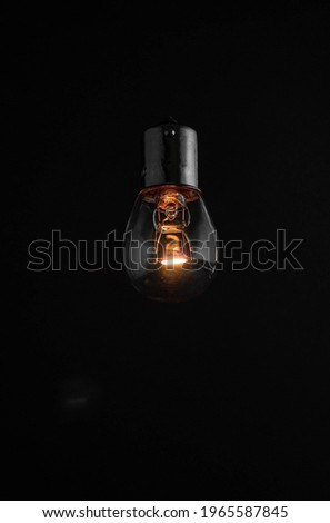 Old dusty light bulb glowing in the dark