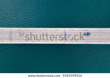 Aerial view of bridge road with cars over lake or sea. High quality photo.