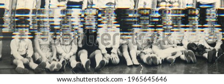 Vintage glitch photo of group of schoolmates kids in their classroom. Retro photo shows small pupils in the classroom. Blackboard on the background. 