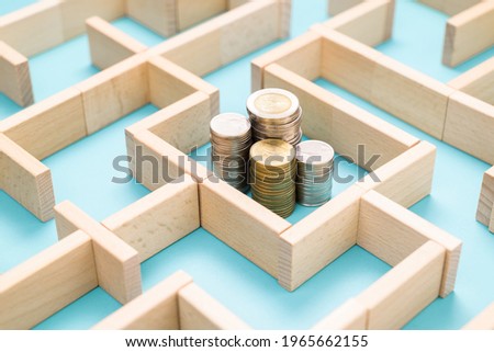 Group of coins heaps in the maze game built by wood blocks, find a way to money resource, business budget, making money concept Royalty-Free Stock Photo #1965662155