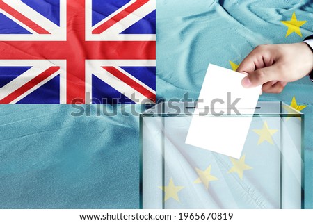tuvalu flag, tuvalu  the symbol of elections Male hand puts down a white sheet of paper with a mark as a symbol of a ballot paper against the background of the 
