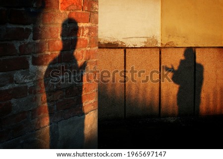 Shadows of two people on the different walls