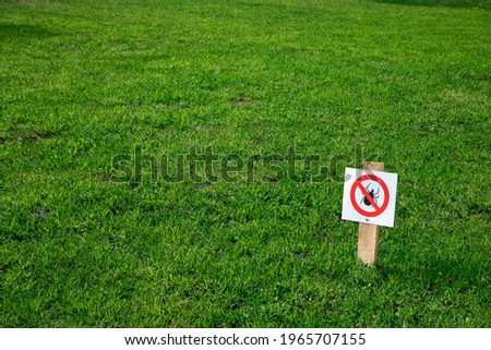 Green lawn treated with mite repellent. A sign indicating that there are no mites in the grass. Safe place for games and picnics. Copy space for labels and text.