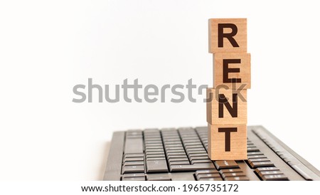 rent in 3d wooden alphabet letters on a keyboard background with copy space, business concept