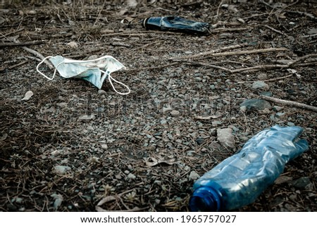 Environment. Plastic garbage in woodland. Rubbish trash, waste and medical mask in forest. Ecological problem with Empty used bottles of big city