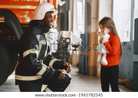 Portrait of a firefighter standing in front of a fire engine Royalty-Free Stock Photo #1965782545