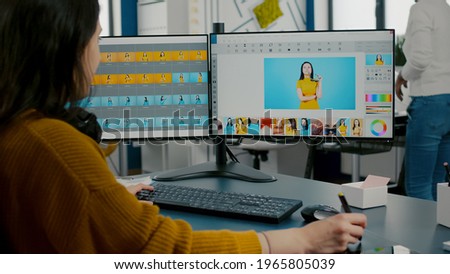 Woman designer, photo editor specialist working at pc in creative office environment using stylus pencil. Retoucher woman retouching fashion assets in digital graphics editing software, color grading