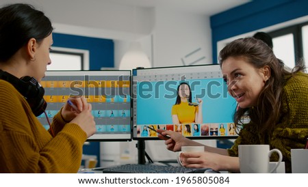 Art director teaching retoucher employee how to color gread female portret using photo editing software. Graphic designers analysing client assets from displays and taking notes in creative agency