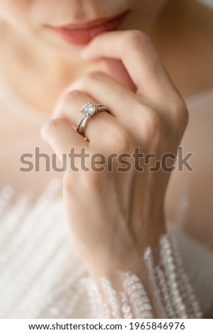 Ring Finger; an Engagement ring with a bride's white wedding dress
