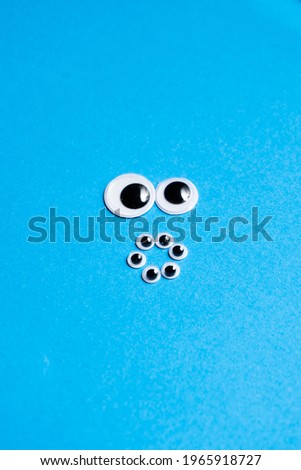 Smileys from toy eyes on a blue background