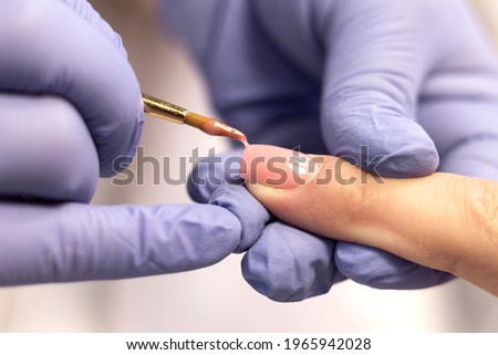Manicure. Strengthening of natural nails with artificial material-gel. Nail care in a beauty salon. Close-up Royalty-Free Stock Photo #1965942028