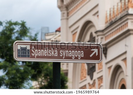 Street sign pointing to Spanish synagogue (Spanelska synagoga) in Prague Jewish Quarter with the buildng itself in the background, shallow depth of field Royalty-Free Stock Photo #1965989764