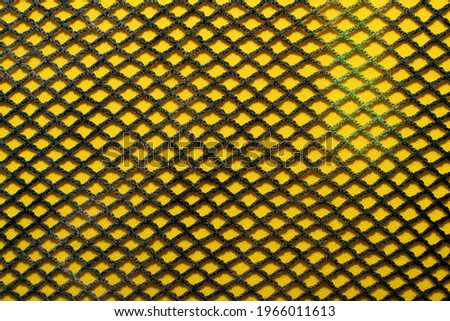 Cloth. Textiles. Fabric background with mesh. The mesh piece of fabric is yellow in color. Grid
