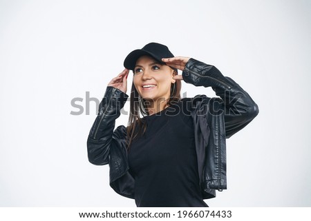 attractive girl in a black jacket and cap. photo session in the studio.